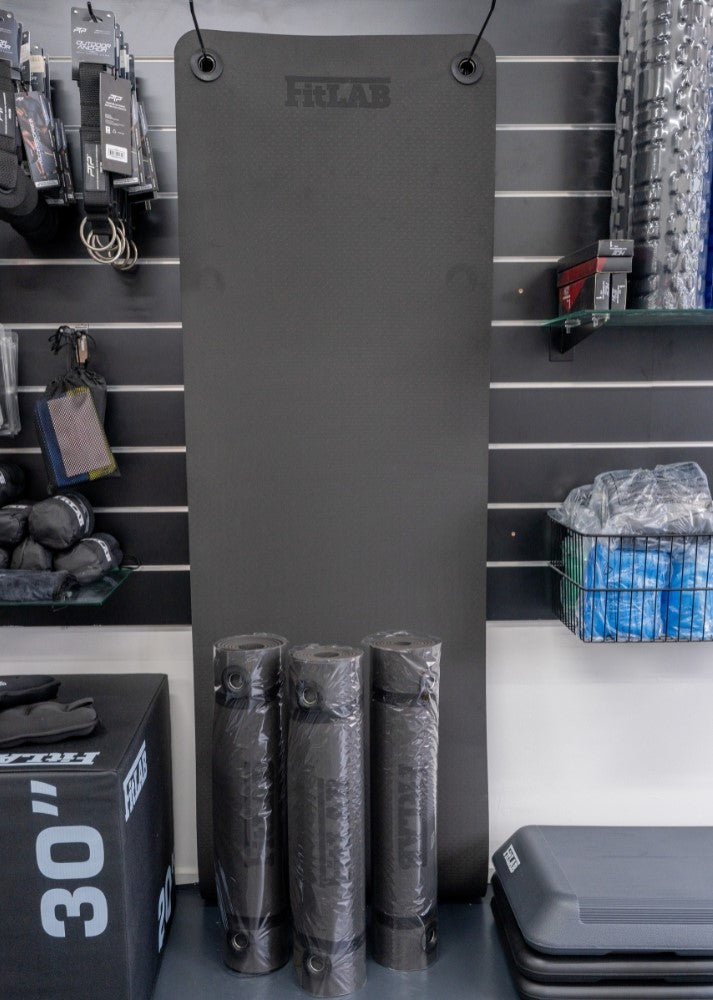 A rolled up black Fitlab thick Anti Slip yoga mat with the brand logo visible, presented during a clearance sale.